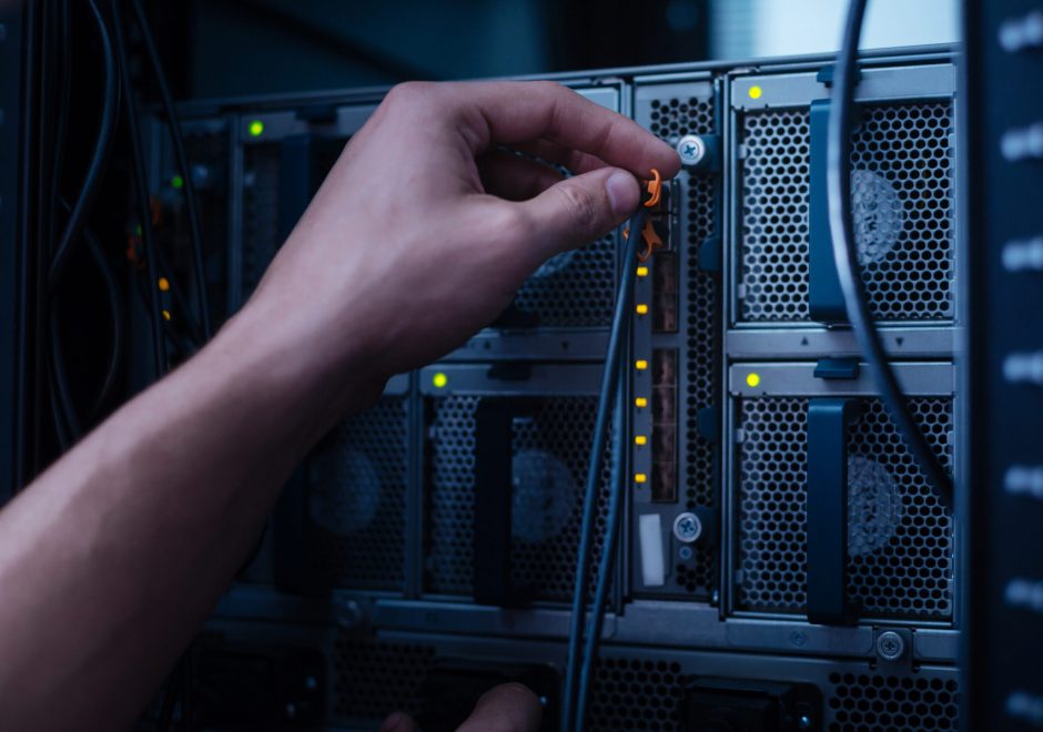 Picture of a person plugging network cables on a computer